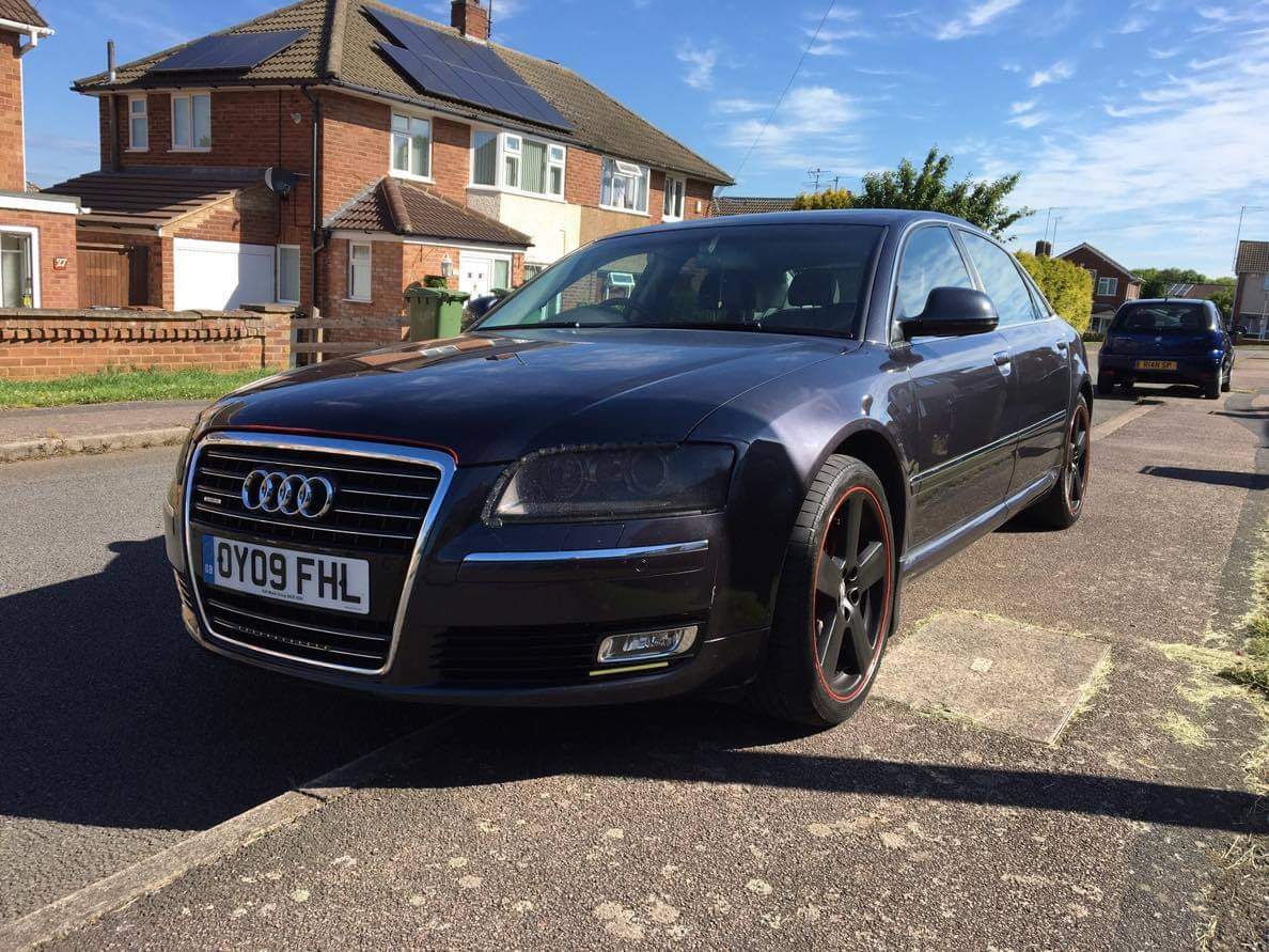 A dark Audi photographed at a front three-quarter angle