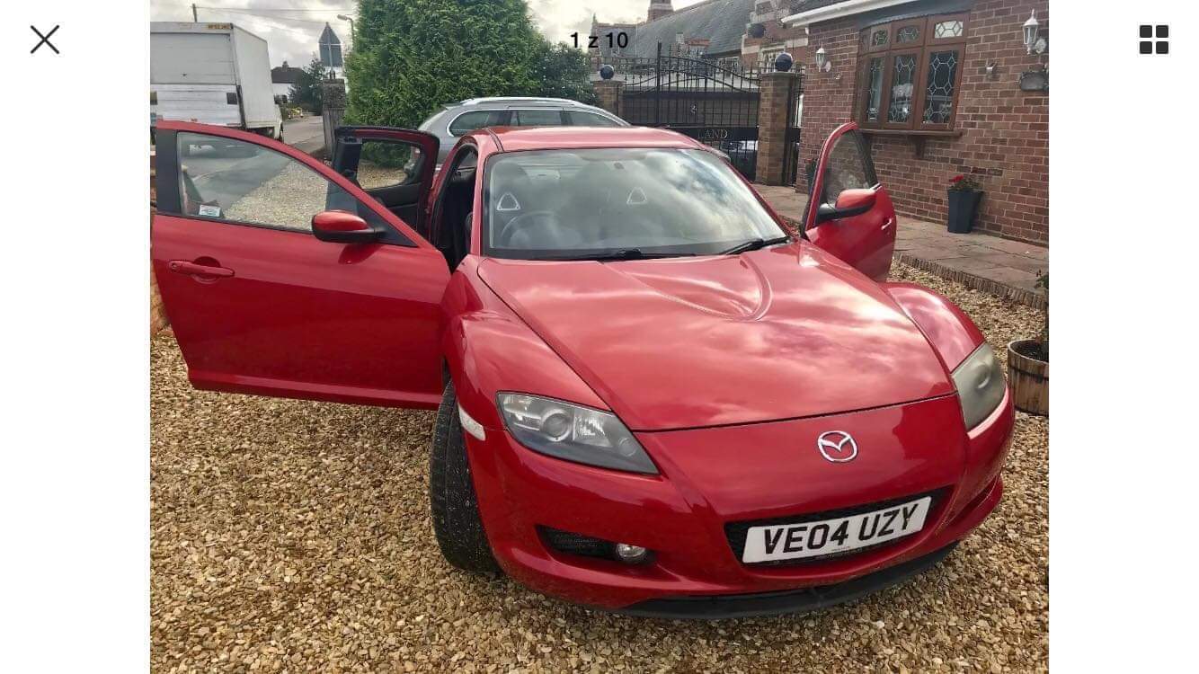 A red Mazda photographed with its doors open